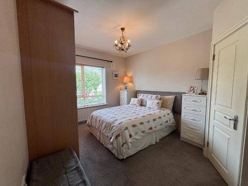 a bedroom with a bed and a dresser and a window at Spacious 2 Bed Apartment near Dublin Airport in Celbridge