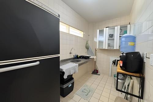 kuchnia z czarną lodówką i zlewem w obiekcie Lindo Apê dois quartos em frente ao mar na Barra de São Miguel w mieście Barra de São Miguel