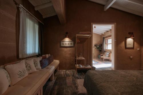 a bedroom with a couch and a bed in a room at MANEJ URLA in Izmir