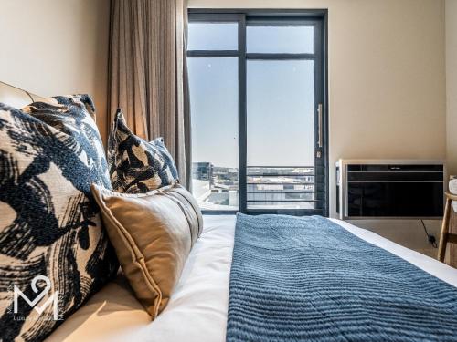a bedroom with a bed with a large window at Menlyn Maine Luxury Rentals in Pretoria