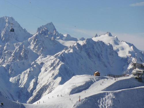 a snow covered mountain with people on a ski slope at Appartement Ô Bouleau in La Tzoumaz