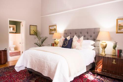 a bedroom with a large bed with white sheets and pillows at KAROO RANCHING Townhouse in Graaff-Reinet
