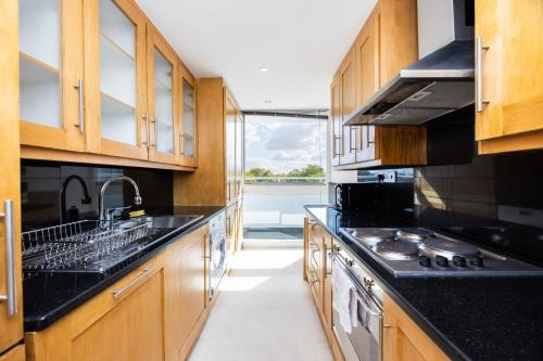 a kitchen with wooden cabinets and black counter tops at Marylebone in London