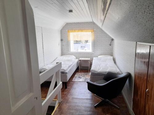 Una habitación con dos camas y una silla dentro. en Cozy country cottage in scenic location near Monsteras, en Alebo