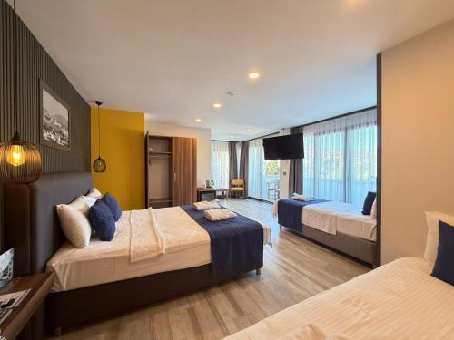 a hotel room with two beds and a television at La Bonita Marina Hotel Bodrum in Bodrum City