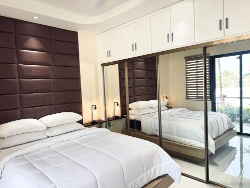 a large bedroom with two beds and a large mirror at The Nest At Paradisiac in Ocho Rios