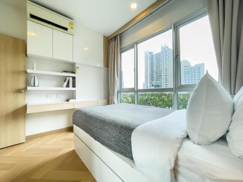 a bedroom with a bed with a large window at Elegant Stay near IconSiam l High-speed WiFi l BTS Wongwian Yai in Godown