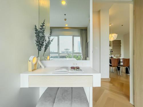a white kitchen with a sink and a mirror at Elegant Stay near IconSiam l High-speed WiFi l BTS Wongwian Yai in Godown