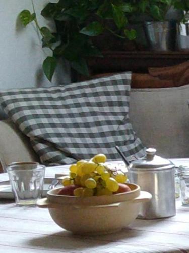 a bowl of grapes sitting on a table with a plate of food at Lo noú b&b in Aosta