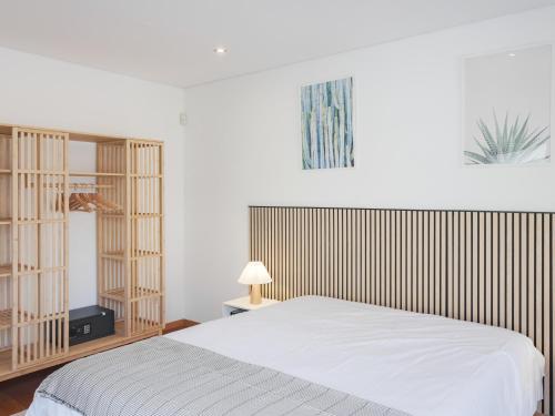 a bedroom with a white bed and wooden shelves at Dom Carlos Villa in Vila Nova de Gaia