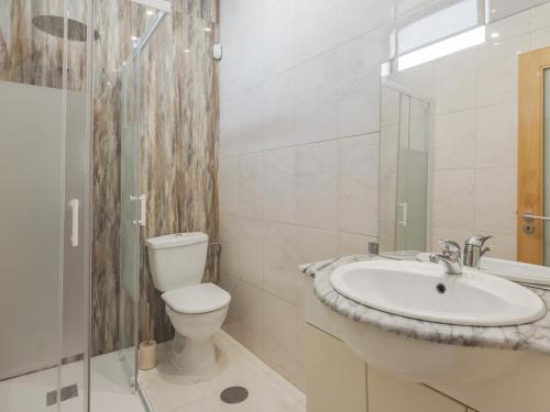 a white bathroom with a toilet and a sink at Dom Carlos Villa in Vila Nova de Gaia
