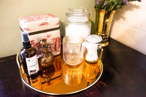 a tray with bottles and glasses on a table at KAROO RANCHING Townhouse in Graaff-Reinet