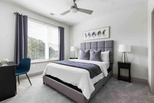 a bedroom with a large bed and a blue chair at Blissful Living 5 Min From Downtown in Wilders Grove