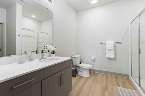 a white bathroom with a sink and a toilet at Blissful Living 5 Min From Downtown in Wilders Grove