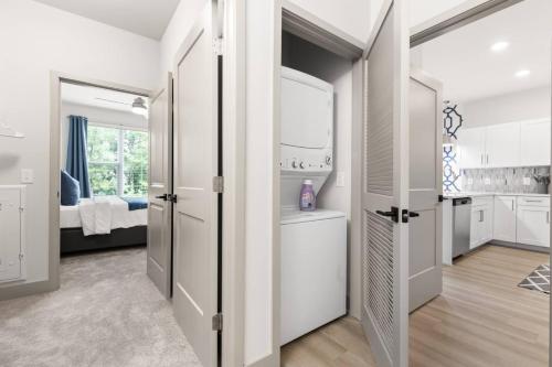 een keuken met witte kasten en een kamer met een bed bij Unique Living 5 Min From Downtown in Wilders Grove