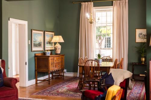 a living room with a table and chairs and a window at KAROO RANCHING Townhouse in Graaff-Reinet