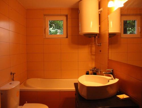 a bathroom with a tub and a sink and a toilet at ART HOUSE Kosmaj 1 in Sopot