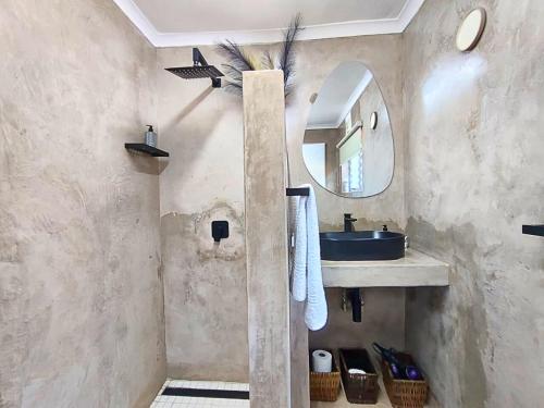 a bathroom with a sink and a mirror at Cosy Beach Cottage 52 Chaka's Rock Chalets Resort in Ballito