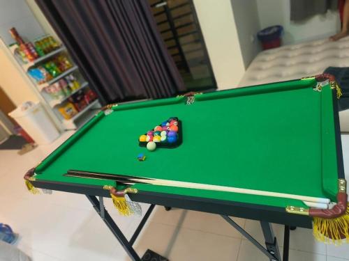 una mesa de billar verde con una bola de billar en Mommy Homestay Kuala Terengganu private pool, en Kuala Terengganu