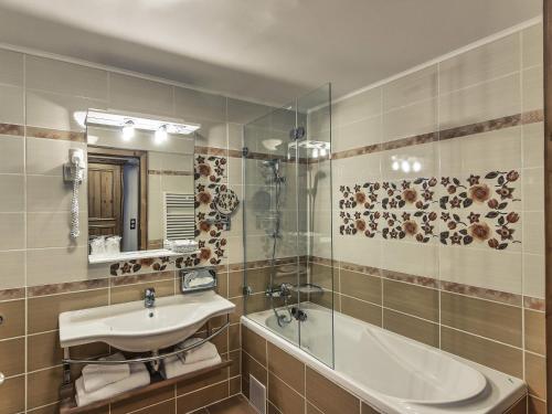 a bathroom with a sink and a mirror at Mercure Sighisoara Binderbubi Hotel & Spa in Sighişoara