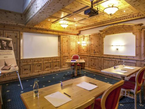 a room with two tables and a projection screen at Mercure Sighisoara Binderbubi Hotel & Spa in Sighişoara