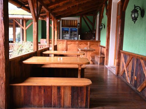 an empty restaurant with wooden tables and benches at Mercure Sighisoara Binderbubi Hotel & Spa in Sighişoara