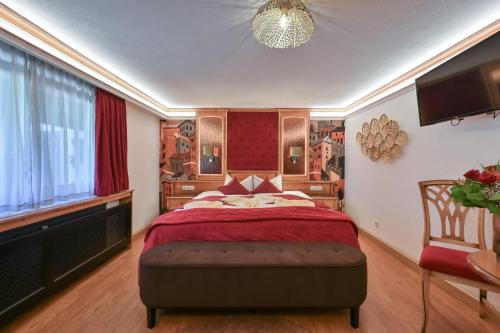 a bedroom with a large bed with a red headboard at Hotel San Marco in Füssen