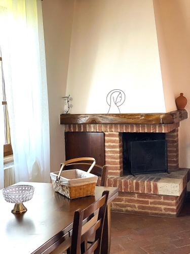a living room with a fireplace and a wooden table at Villa Tiberini - Wine Relais in Torrita di Siena