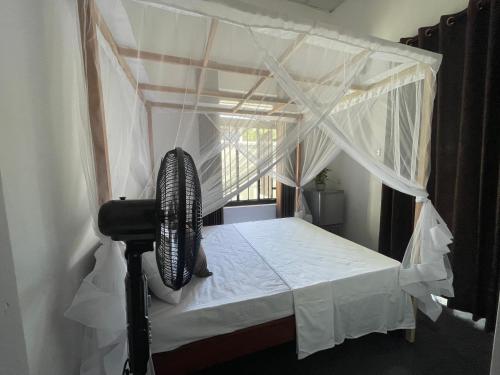 a bedroom with a canopy bed with white curtains at Villa Bellissimo - Hiriketiya in Dickwella