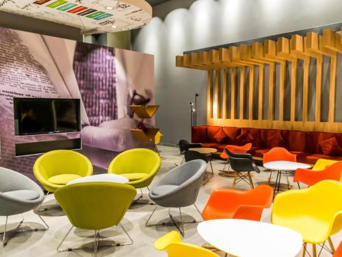 a room with colorful chairs and tables at ibis Copiapo in Copiapó