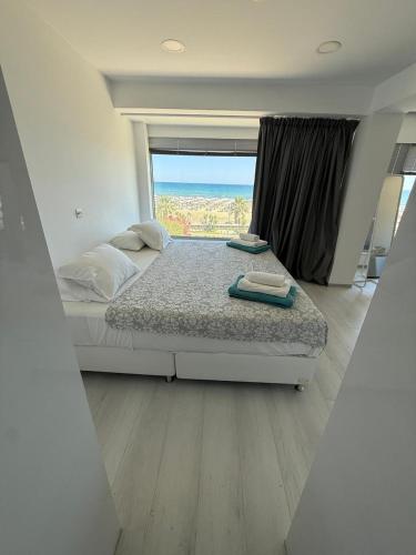 une chambre avec un lit et une grande fenêtre dans l'établissement Marimar2 paradise by the Sea, à Larnaka