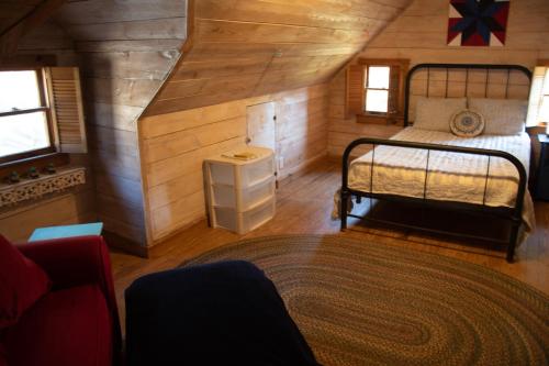 a small bedroom with a bed in a cabin at Project Chimps Historic Cabin in Morganton