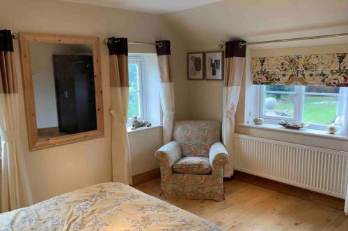 a bedroom with a bed and a chair and a window at 2-Bedroom Cottage with 2 Ensuites - Sleeps 6 Wifi in Rye
