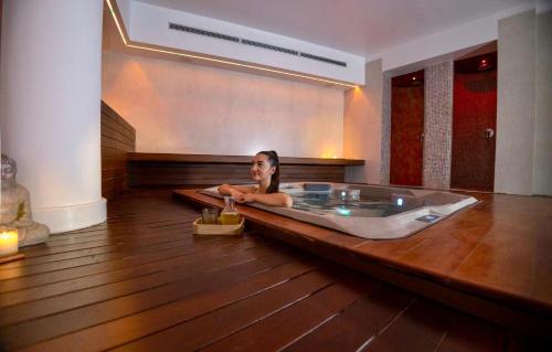 a woman sitting in a bath tub in a room at Hyde Park Lane in Puerto del Carmen