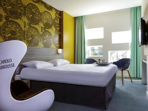 ミュルザンヌにあるibis Styles Le Mans Sud Mulsanneのベッド2台と机があるホテルの部屋