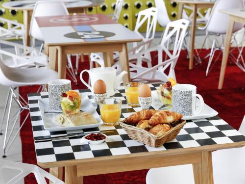 a table with a breakfast of eggs and croissants at ibis Styles Le Mans Sud Mulsanne in Mulsanne