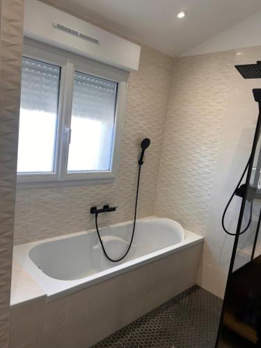a bath tub in a bathroom with a window at Maison de Saint-Denis-en-Bugey in Saint-Denis-en-Bugey