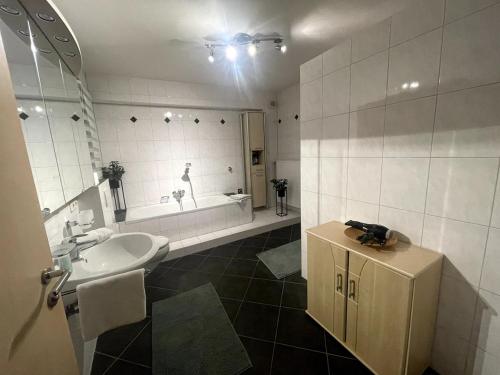 a bathroom with a sink and a bath tub at Traumhafte Gartenwohnung in Pfaffenhofen an der Ilm