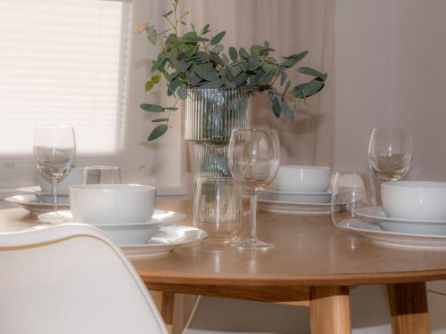 a wooden table with a vase of flowers and glasses at 217 Schortens in Schortens