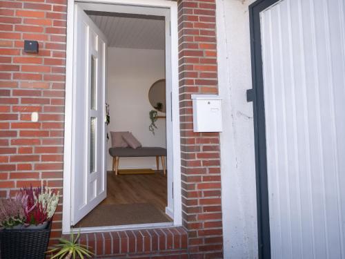 an open door to a brick building with a chair at 217 Schortens in Schortens