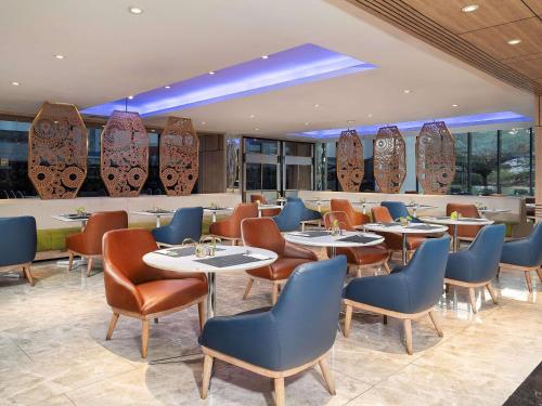 a restaurant with tables and chairs and a bar at Mercure Bandung City Centre in Bandung