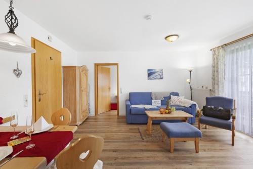 オーバーアウドルフにあるFewo Brünnstein - Nr 35 Romantikの青いソファとテーブルのあるリビングルーム
