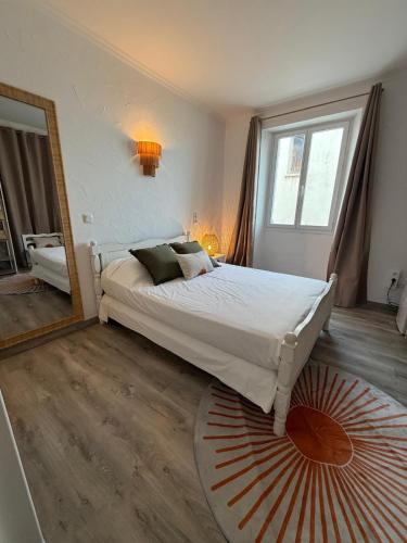 a bedroom with a large bed and a large mirror at Hôtel Les 3 Terrasses in Sari Solenzara