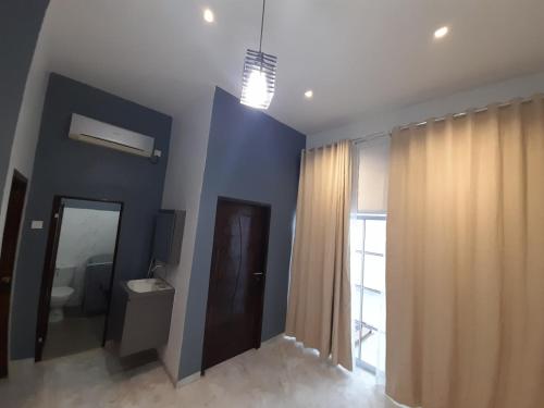 a bathroom with blue walls and curtains and a mirror at JH homestay 