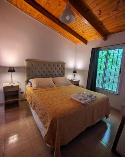 a bedroom with a bed and a large window at La caballeriza departamentos in Alta Gracia