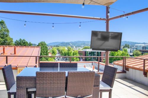 a table and chairs with a television on a balcony at Elevator-Work Here-Gig WiFi-King Bed-Laundry in unit in Walnut Creek