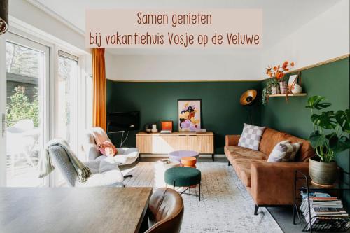 a living room with a couch and a table at Luxe Vakantiehuis Vosje op de Veluwe Nunspeet in Nunspeet