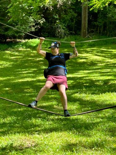 a man standing on a rope in the grass at Project Chimps Historic Cabin in Morganton