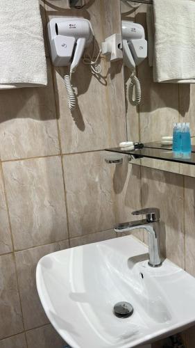 ein Waschbecken im Badezimmer mit zwei Lichtern an der Wand in der Unterkunft واجهةالشرقيةللضيافةالخاصة in Khobar