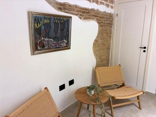 a room with two chairs and a table and a painting at Charming Boutique B&B Hotel in Villalfonsina